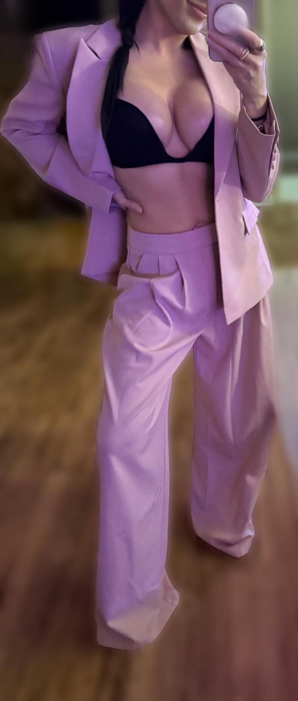 woman posing in oversized pink business suit being guoofy.