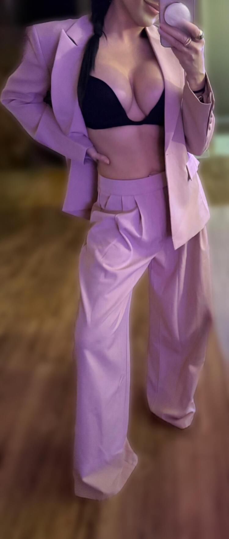 woman posing in oversized pink business suit being guoofy.